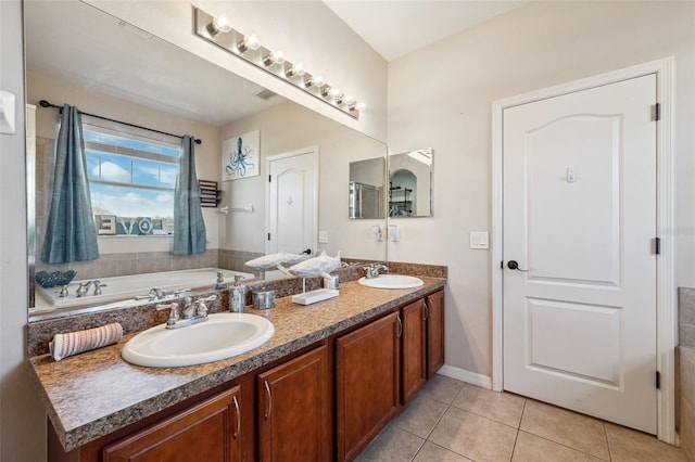 bathroom with double vanity, a sink, a bath, and tile patterned floors