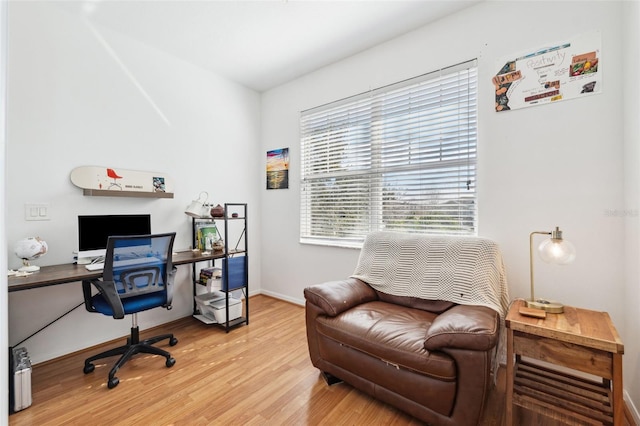 home office with baseboards and light wood finished floors