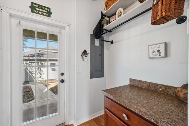 doorway featuring electric panel and baseboards