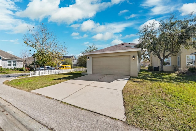 exterior space with a garage, stucco siding, fence, and a yard