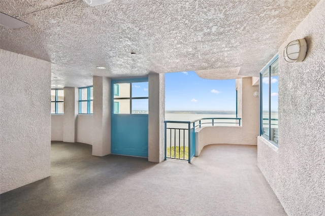 carpeted empty room with a textured ceiling