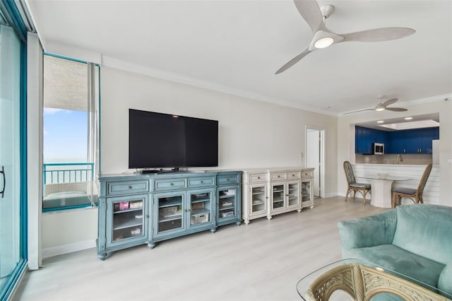 living room featuring ornamental molding, light wood-type flooring, and ceiling fan