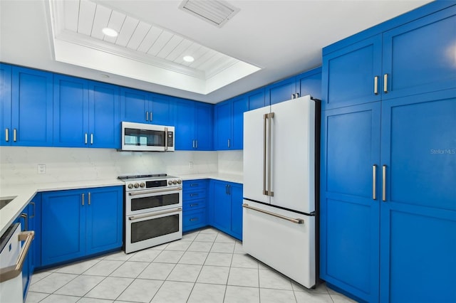 kitchen featuring high quality appliances, a raised ceiling, blue cabinetry, and crown molding