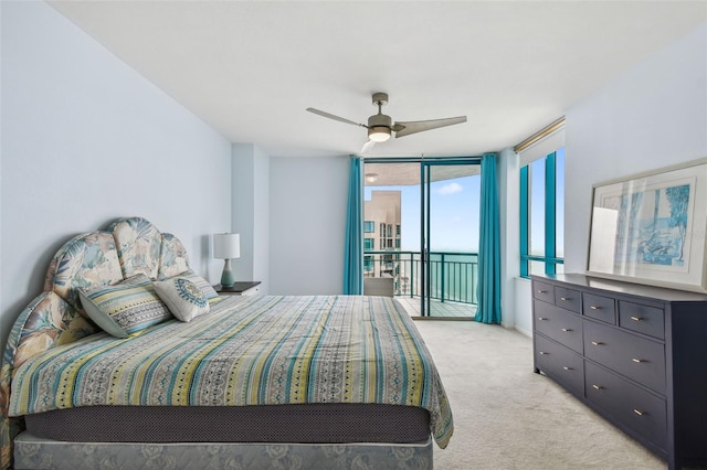 bedroom with ceiling fan, light colored carpet, access to exterior, and a wall of windows