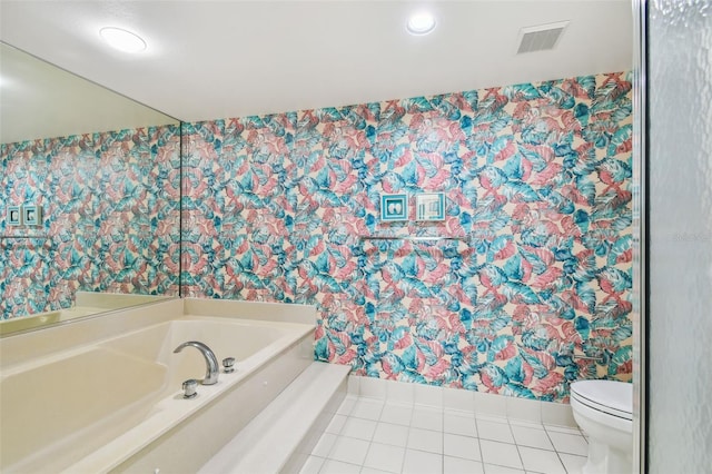 bathroom featuring toilet, tile patterned floors, and a tub to relax in