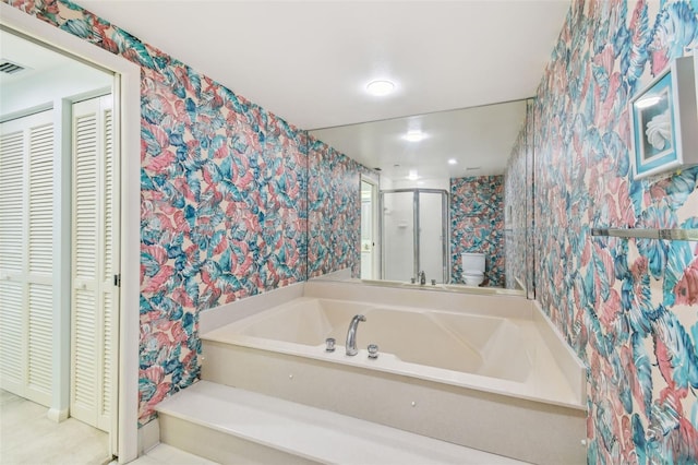 bathroom featuring separate shower and tub and toilet