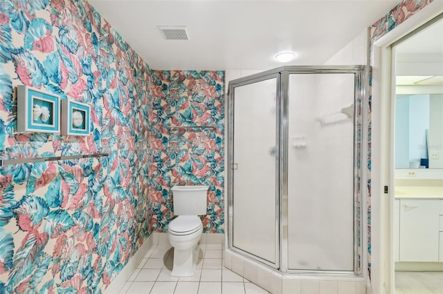 bathroom featuring tile patterned flooring, toilet, vanity, and a shower with shower door