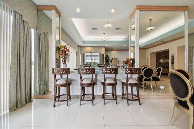 kitchen featuring light tile patterned floors, decorative light fixtures, and a raised ceiling