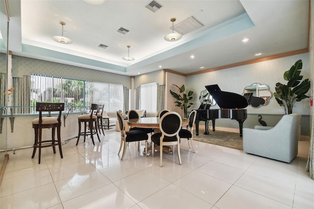 tiled dining room featuring crown molding and a raised ceiling