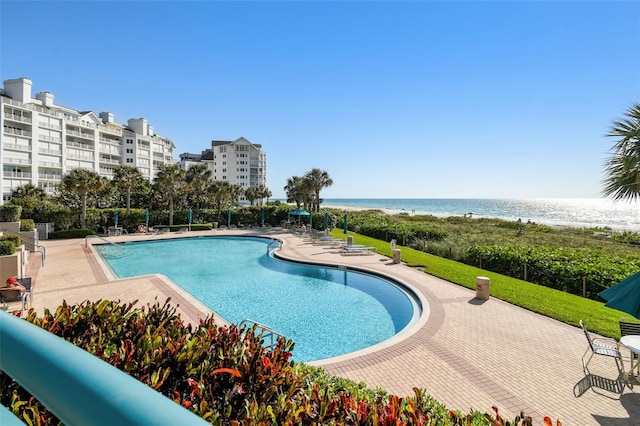 view of swimming pool featuring a water view and a patio area