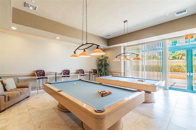 game room with light tile patterned floors, billiards, and a textured ceiling