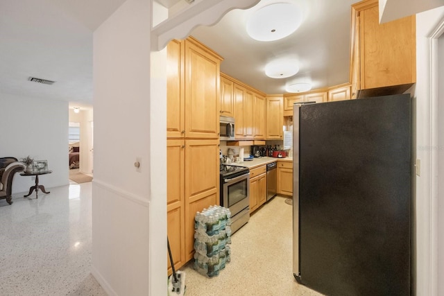 kitchen featuring stainless steel appliances and light brown cabinetry