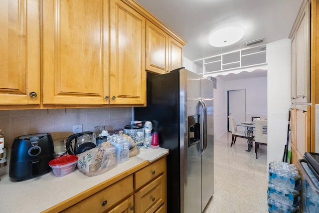 kitchen featuring stainless steel fridge and backsplash