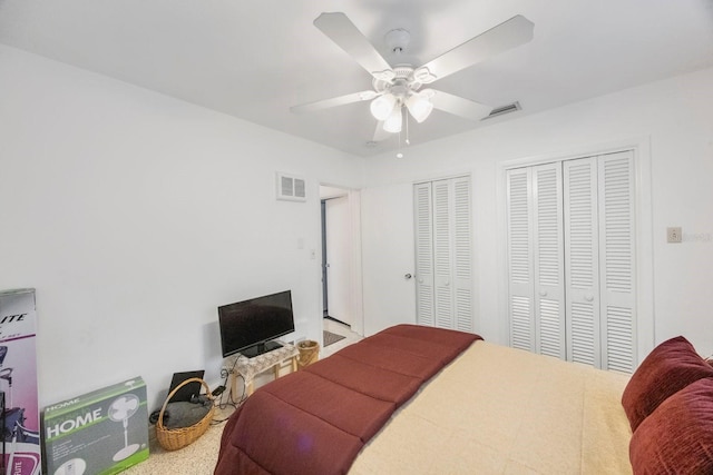 bedroom with multiple closets and ceiling fan