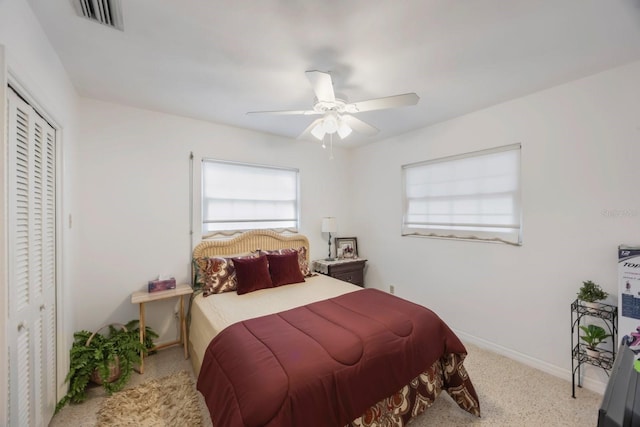 carpeted bedroom with ceiling fan and a closet