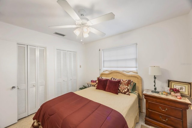 carpeted bedroom featuring two closets and ceiling fan