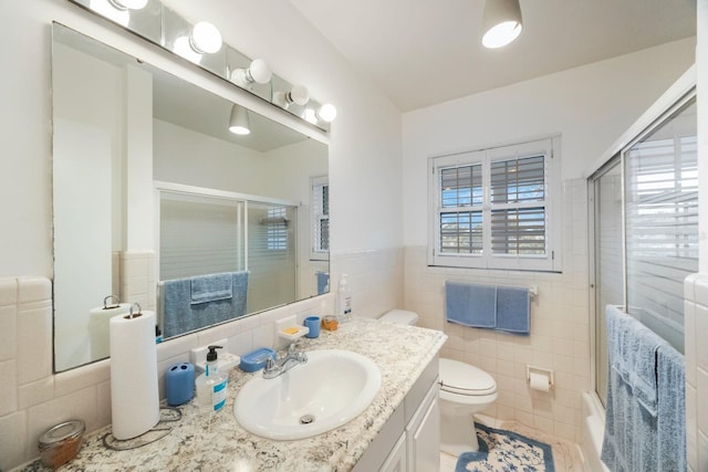 bathroom with tile walls, vanity, tile patterned flooring, and toilet