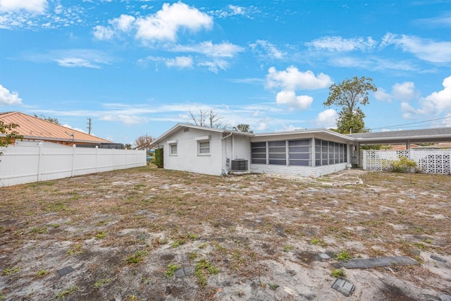 rear view of property featuring a sunroom and central AC unit