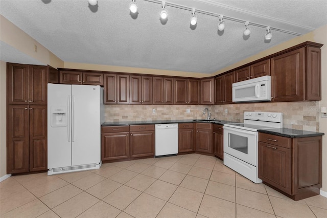 kitchen featuring light tile patterned floors, a textured ceiling, white appliances, and decorative backsplash