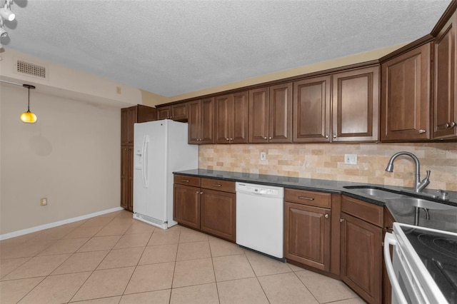 kitchen featuring pendant lighting, sink, white appliances, light tile patterned floors, and decorative backsplash