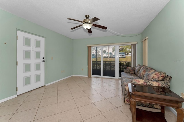 tiled living room with a textured ceiling and ceiling fan