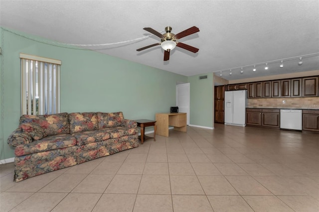 tiled living room with a textured ceiling and ceiling fan