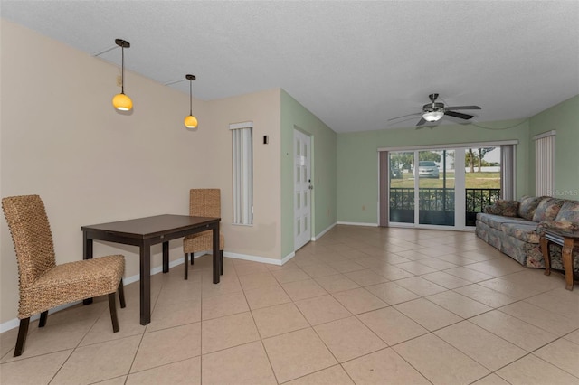 tiled living room with ceiling fan and a textured ceiling