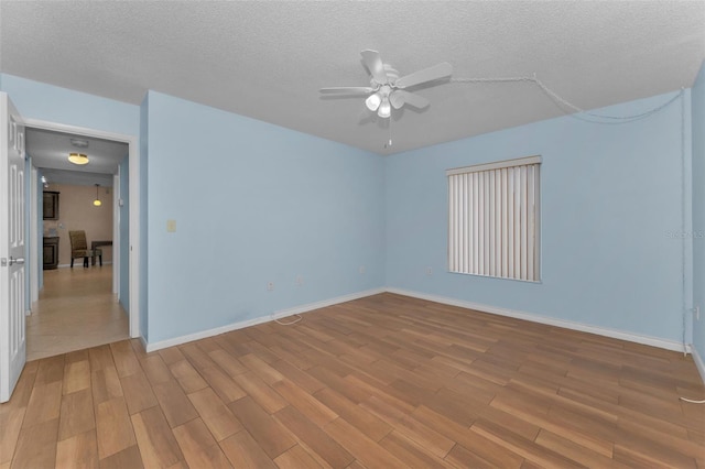 unfurnished room with ceiling fan, light hardwood / wood-style floors, and a textured ceiling