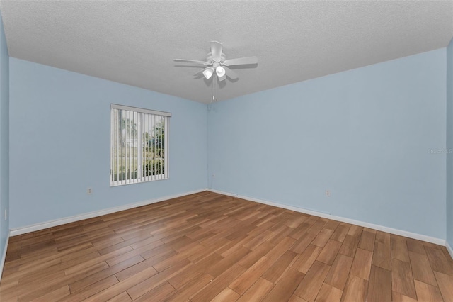 empty room with ceiling fan, a textured ceiling, and light wood-type flooring