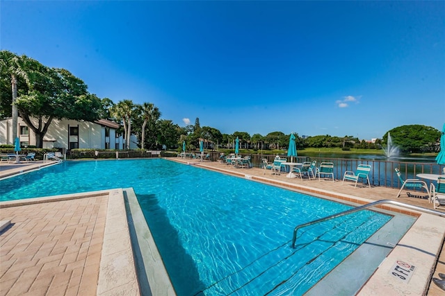 view of pool with a patio and a water view