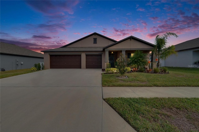 ranch-style home with a garage and a lawn