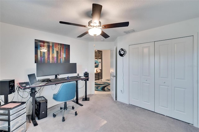 carpeted office space featuring a textured ceiling and ceiling fan