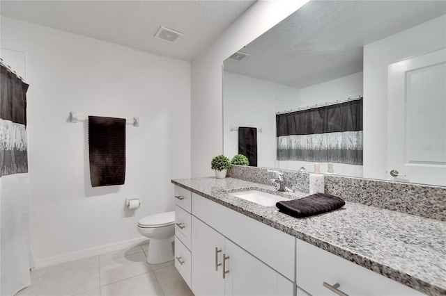 bathroom featuring vanity, tile patterned flooring, and toilet