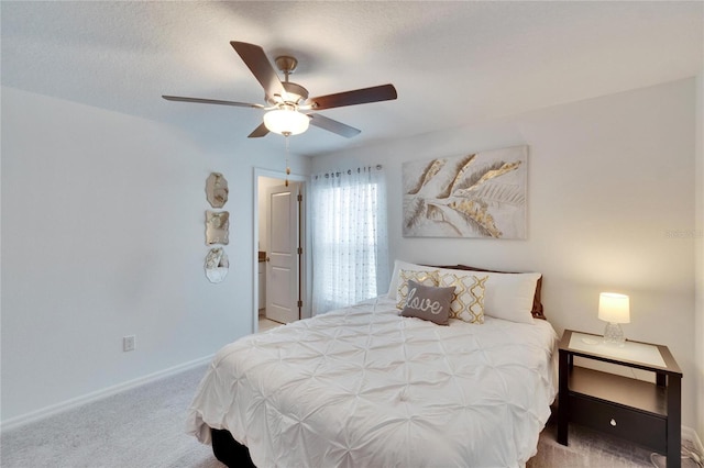 carpeted bedroom featuring ceiling fan and a textured ceiling