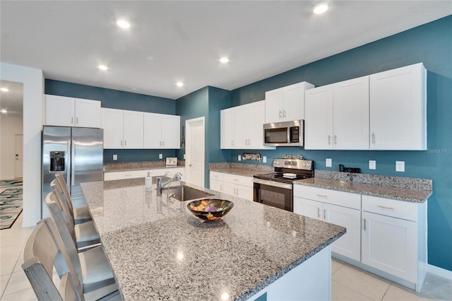 kitchen featuring appliances with stainless steel finishes, sink, a center island with sink, and white cabinets