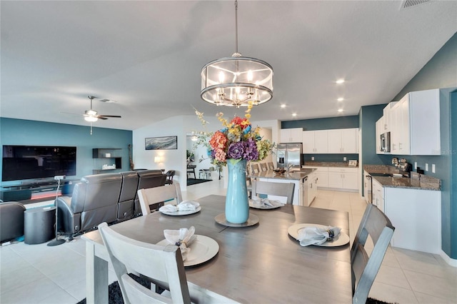 tiled dining area featuring ceiling fan with notable chandelier and vaulted ceiling