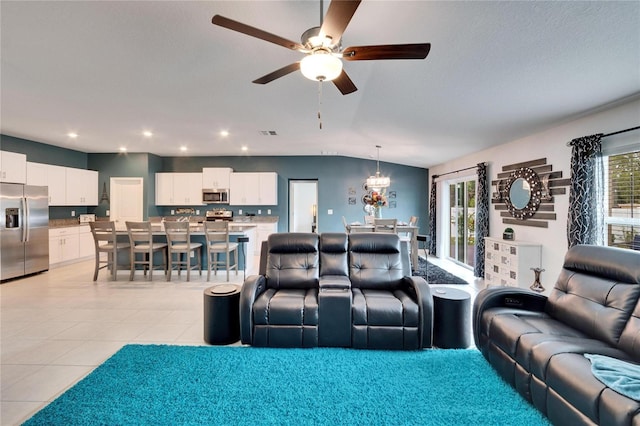 home theater room with vaulted ceiling, light tile patterned floors, and ceiling fan