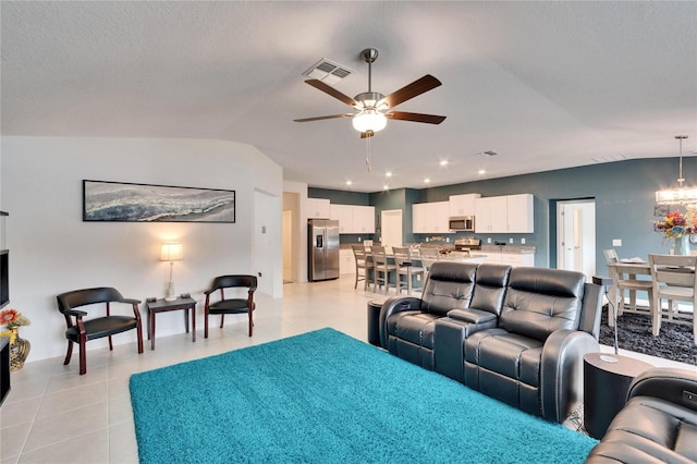 tiled living room featuring lofted ceiling, ceiling fan with notable chandelier, and a textured ceiling