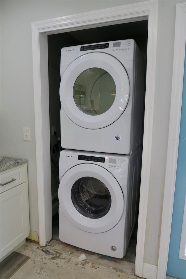 clothes washing area featuring stacked washing maching and dryer