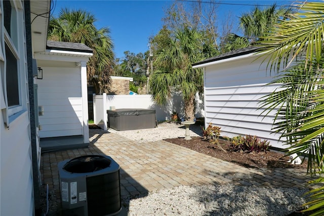 view of patio with a hot tub and central AC