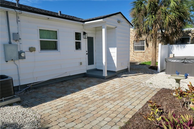 exterior space with a hot tub and central AC unit