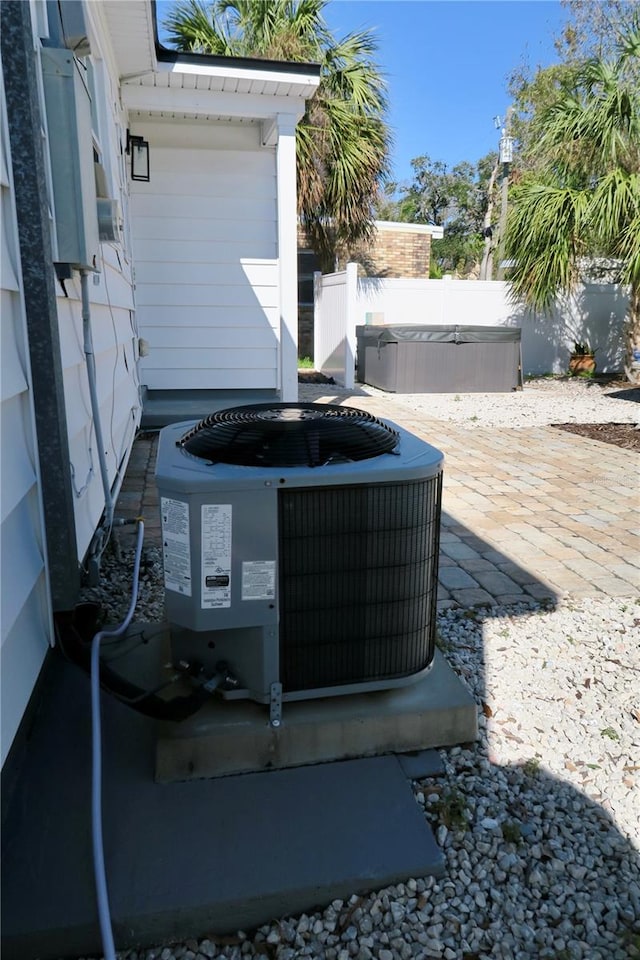 exterior details featuring cooling unit and a hot tub