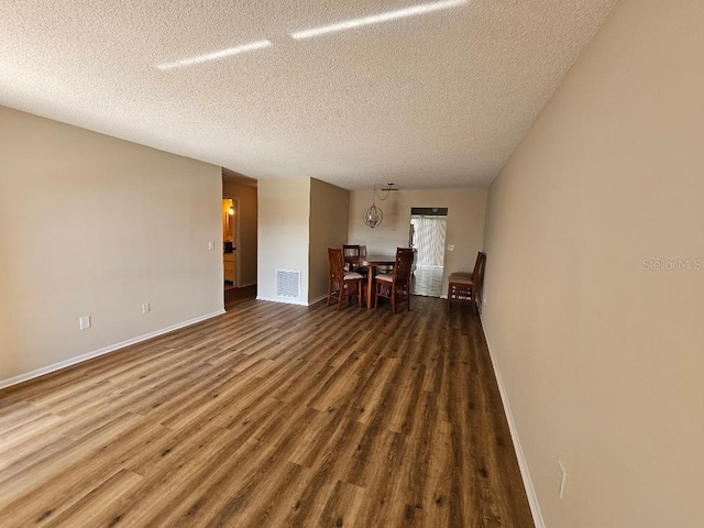 unfurnished room with dark hardwood / wood-style flooring and a textured ceiling