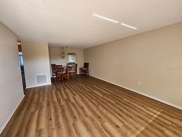 unfurnished room with dark hardwood / wood-style flooring and a textured ceiling