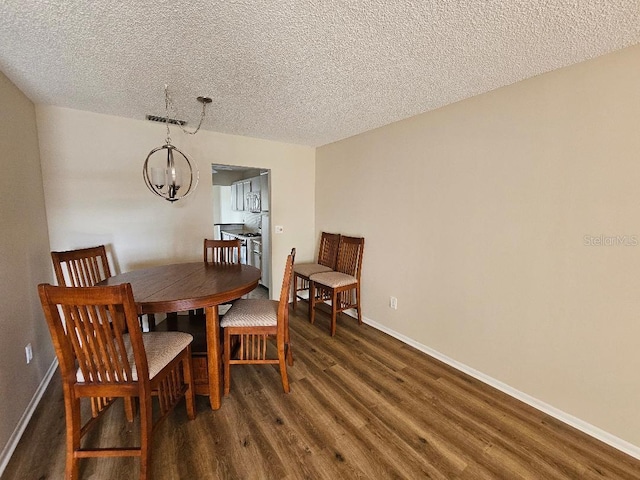 dining space with dark hardwood / wood-style floors, a chandelier, and a textured ceiling