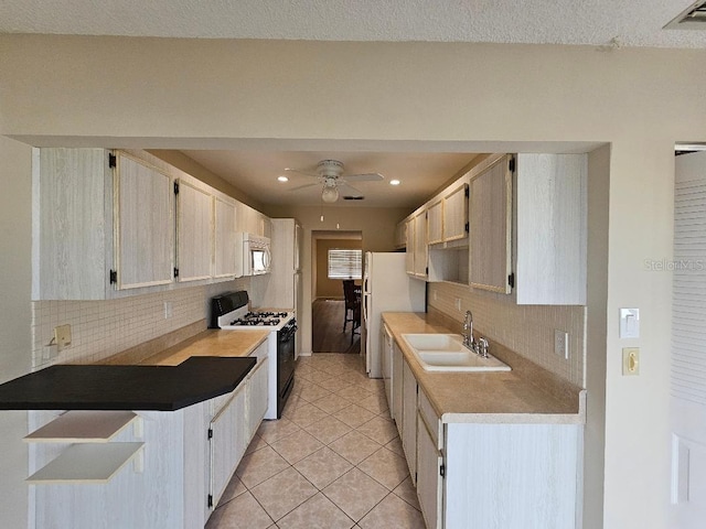 kitchen with tasteful backsplash, sink, white appliances, and ceiling fan