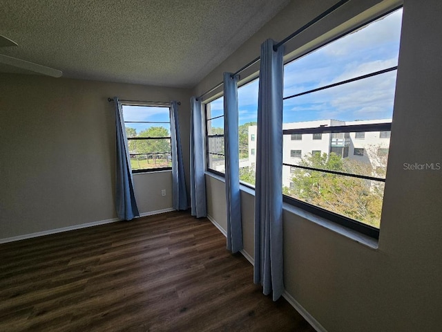 empty room featuring dark hardwood / wood-style floors and a textured ceiling