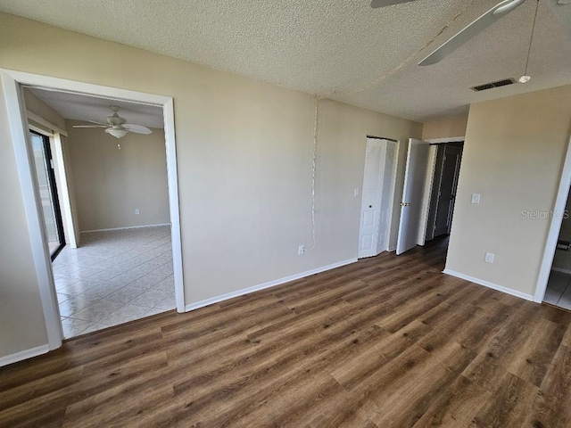 unfurnished room featuring ceiling fan, dark hardwood / wood-style floors, and a textured ceiling