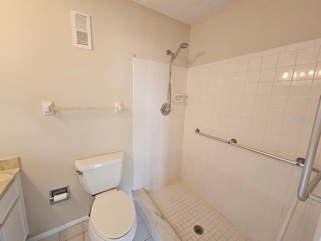 bathroom featuring tile patterned flooring, vanity, toilet, and a tile shower