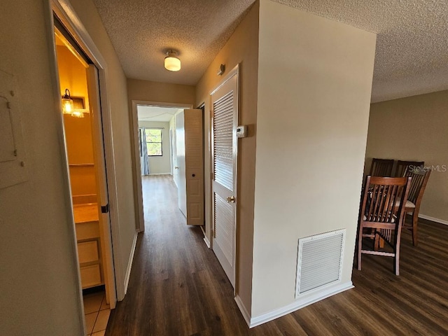 hall featuring a textured ceiling and dark hardwood / wood-style flooring